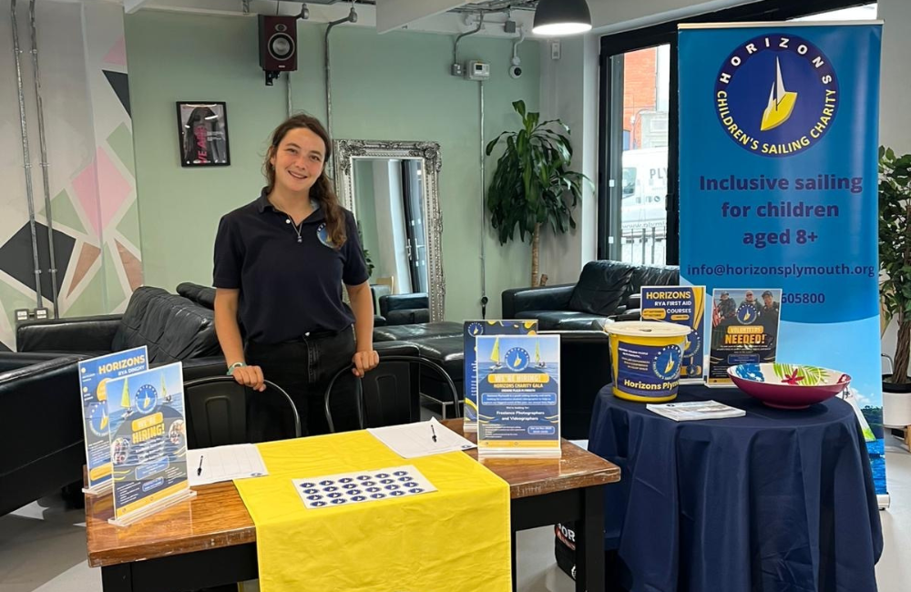 Horizons team member standing with a information stall about the charity
